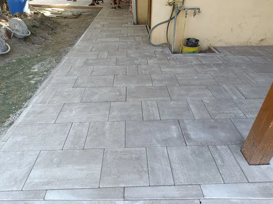 Ház melletti burkolt járda nagyméretű térkőlapokkal